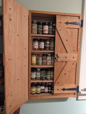 Spice cabinet in cherry with doors open showing spices