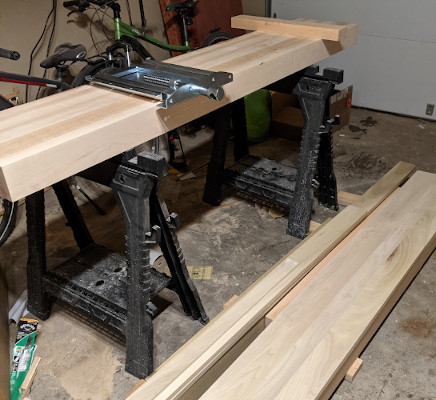 Maple bench-top sitting on a pair of plastic sawhorses with a metal vise on top